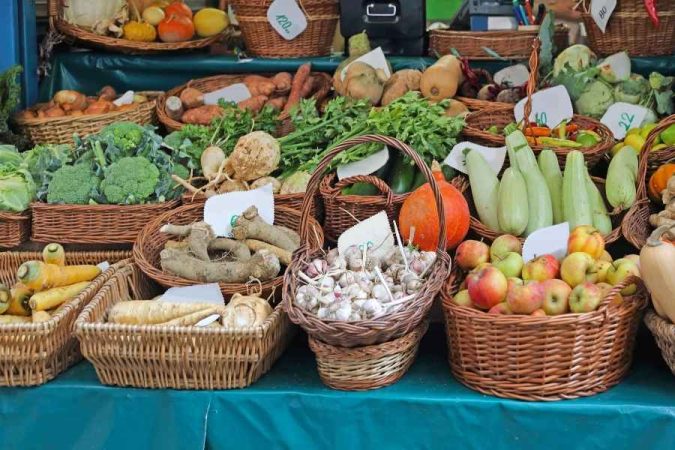 Des paniers en osier remplis de légumes frais sur un marché local pour négocier comme un local.